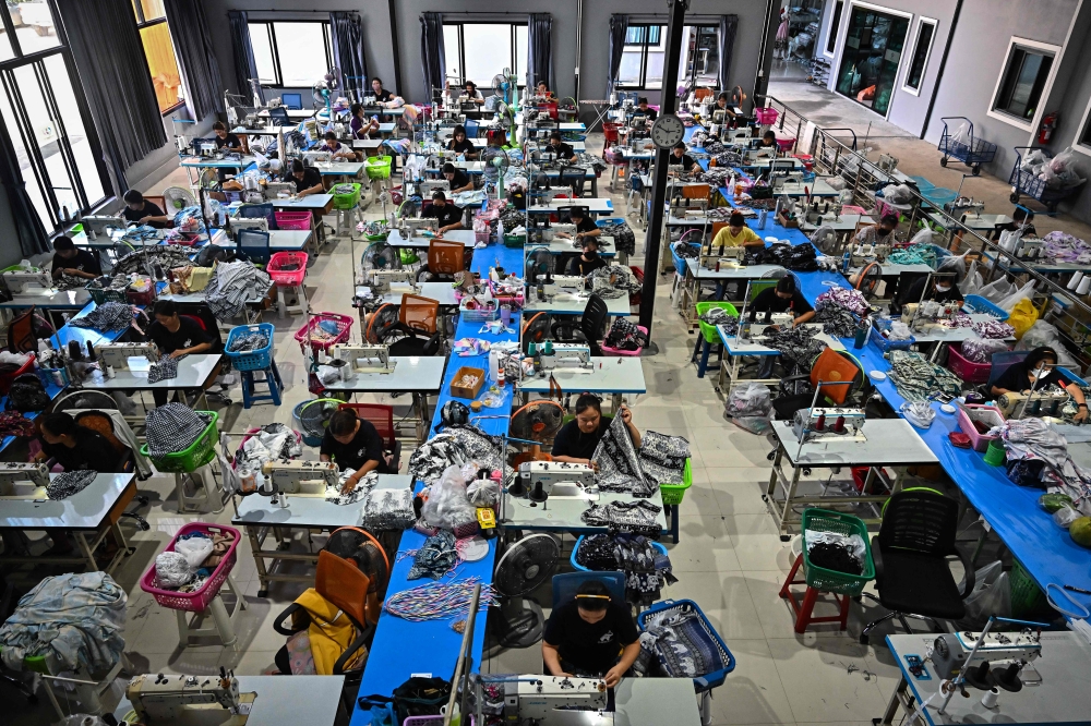 Workers sewing clothing with elephant print and other patterns at Chinrada Garment Co in Chiang Mai. — eNM pic