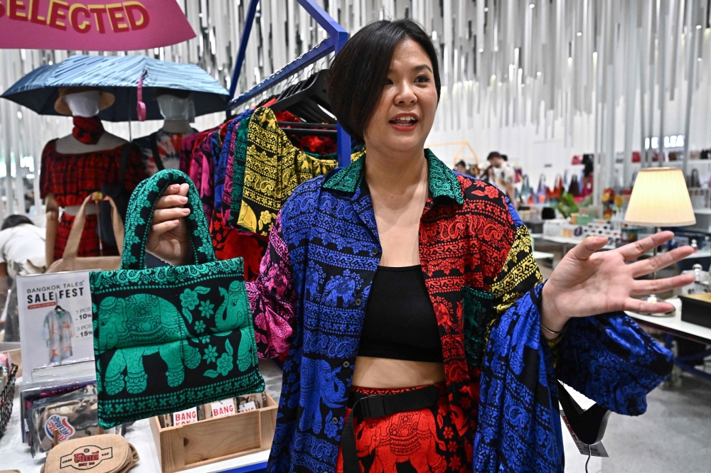 Bangkok Tales clothing brand co-founder and designer Gigi Wo showing her clothing items made with elephant print at Icon Siam shopping mall in Bangkok. — eNM pic