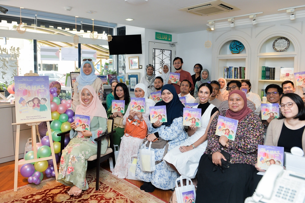 ‘When Love Heals Hate’ book author Murni Wan Mohd Nor poses for a picture with attendees during the launch of the book in Kuala Lumpur November 11, 2023. — Picture by Miera Zulyana