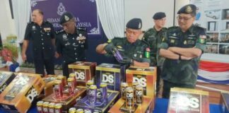 Johor police chief Datuk Kamarul Zaman Mamat with the seized contraband beverages in Pasir Gudang November 29, 2023. ― Picture by Ben Tan