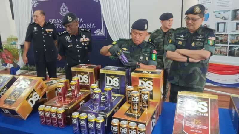 Johor police chief Datuk Kamarul Zaman Mamat with the seized contraband beverages in Pasir Gudang November 29, 2023. ― Picture by Ben Tan