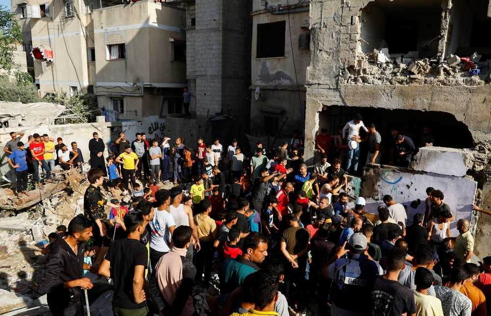 Palestinians gather at the site of Israeli strikes on a residential building, amid the ongoing conflict between Israel and Palestinian Islamist group Hamas, in Khan Younis in the southern Gaza Strip, November 4, 2023. — eNM pic
