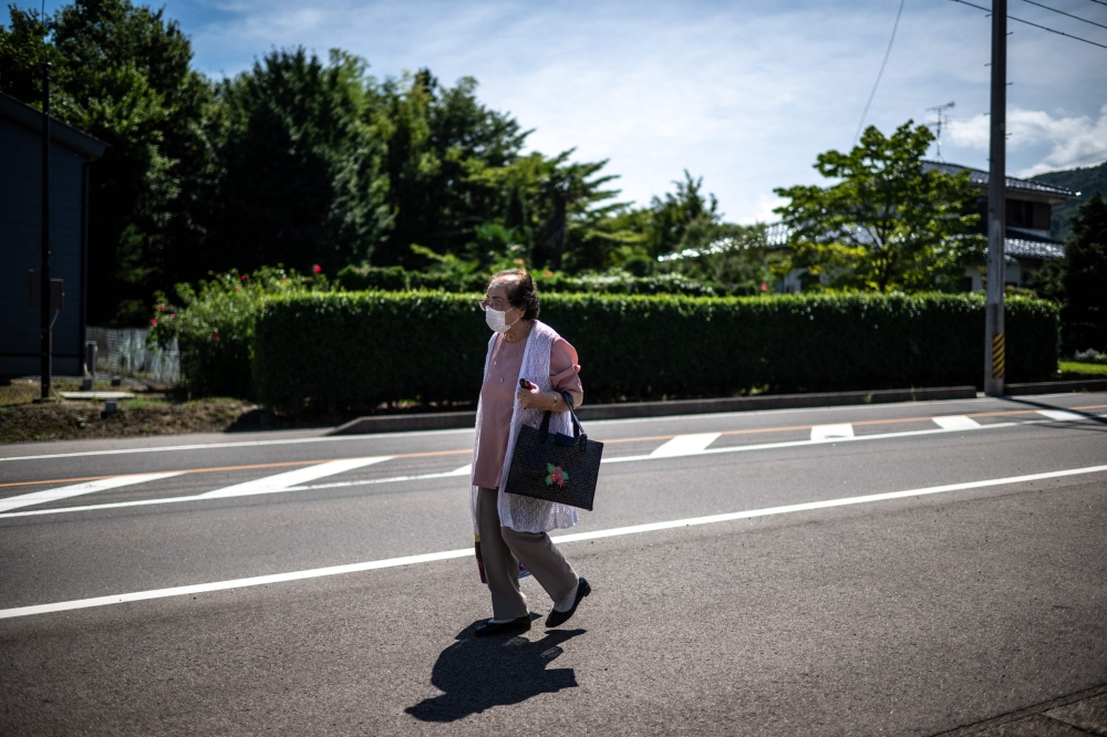  Tomoko Horino waiting for a bus to the office in Fukushima city. — eNM pic