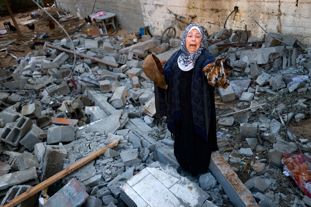 A woman reacts as she salvages belongings from the rubble of a destroyed house following Israeli bombardment in Rafah in the southern Gaza Strip on February 3, 2024, as fighting continues between Israel and the Palestinian Hamas group. — eNM pic
