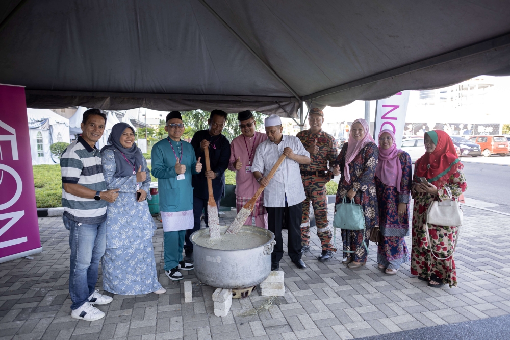 Kasuma Satria, Chief Human Resources Officer and Corporate Communication Director of Aeon (third, left), prepares 'bubur lambuk' with other representative partners. — Picture courtesy of Aeon