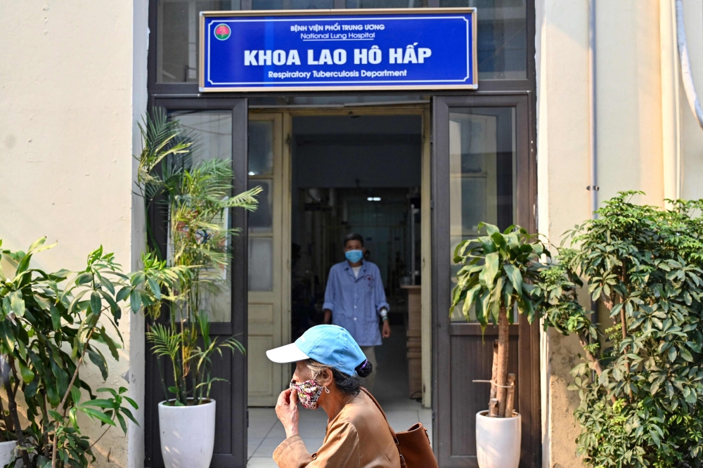 This picture taken on April 2, 2024 shows a woman walking past the entrance of respiratory tuberculosis department at National Lung Hospital in Hanoi. — eNM pic