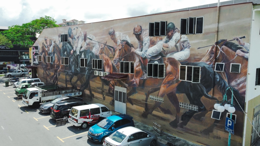 Picture shows Siaw’s second mural at Jalan Padungan, capturing an exhilarating, finely-detailed horse-racing scene. — Picture by Roystein Emmor via The eNM