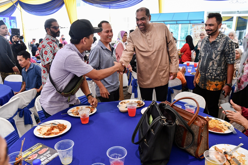 Deputy Minister of Entrepreneur Development and Cooperatives and Sungai Buloh Member of Parliament Datuk R. Ramanan (centre) greets guests at a Hari Raya Open House organised in collaboration with Amanah Ikhtiar Malaysia (AIM) at the Sungai Buloh Parliamentary Service Centre April 28, 2024. — eNM pic