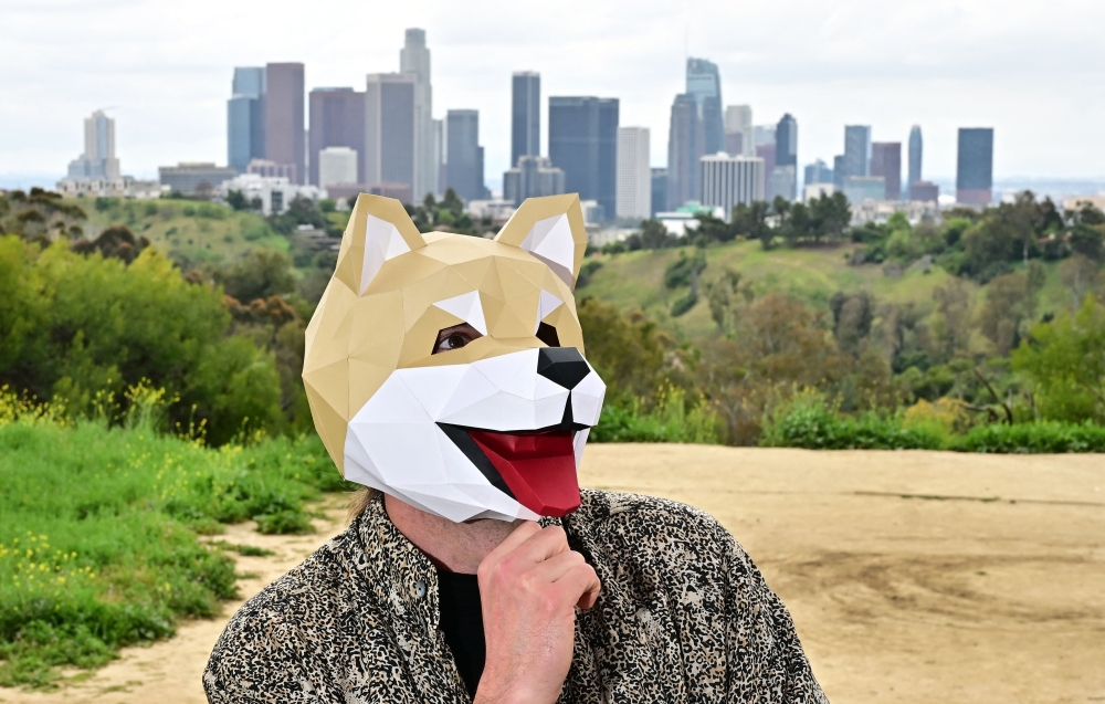 This picture taken on April 4, 2024 shows Tridog, a member of Own the Doge, wearing a Doge mask as he poses for photos during an interview in Los Angeles, California. Own The Doge has brought fans to Japan to meet Kabosu, the shiba inu dog best known as the logo of cryptocurrency Dogecoin. — eNM pic