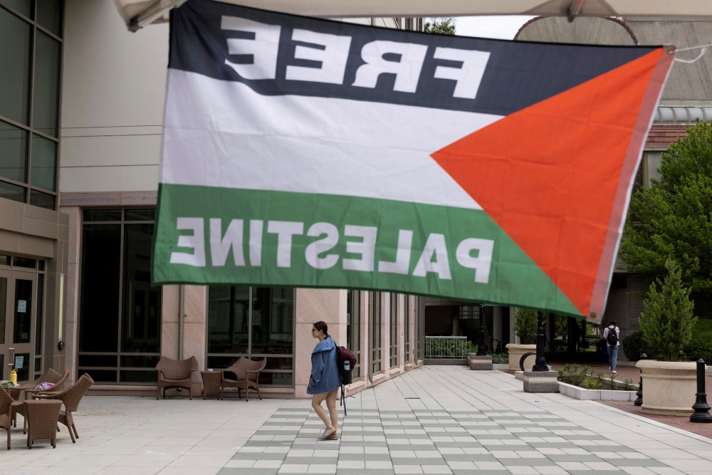 A pro-Palestinian flag is displayed, as students and visitors walk through Emory University’s campus the day after a student protest encampment in support of Palestine ended in arrests during the ongoing conflict between Israel and the Palestinian Islamist group Hamas, in Atlanta, Georgia April 26, 2024. — eNM pic  