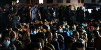Undocumented immigrants are gathered up during a raid by the Immigration Department at the Baiduri Apartment, Taman Tasik Kesuma Beranang, Semenyih January 19, 2024. — eNM pic