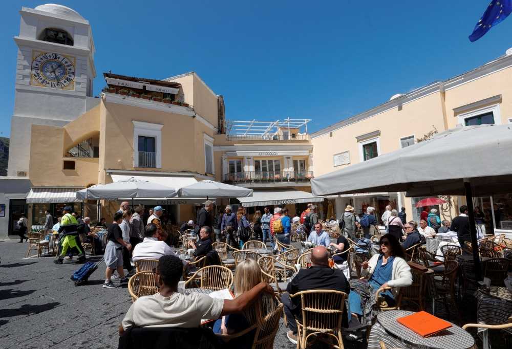 People sit at the tables outside restaurants and cafes on Capri Island, Italy, April 18, 2024. — eNM pic  