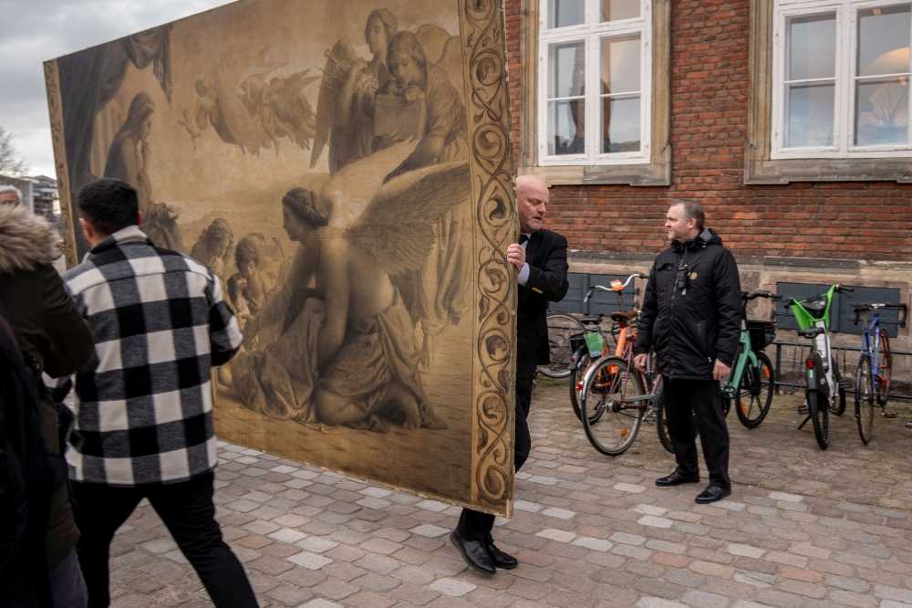 People carry a historic painting out of the Old Stock Exchange, Boersen, during a fire in the historic building, in Copenhagen, Denmark, April 16, 2024. — Ritzau Scanpix/Ida Marie Odgaard pic via eNM 