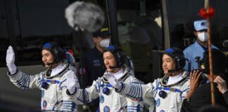 Astronauts for China's Shenzhou-18 space mission (from left) Ye Guangfu, Li Cong and Li Guangsu wave during a departure ceremony before boarding a bus to take them to the Shenzhou-18 spacecraft at the Jiuquan Satellite Launch Centre in the Gobi desert April 25, 2024. — eNM pic