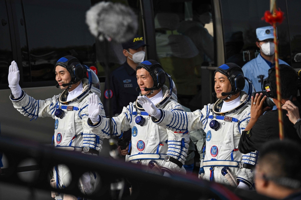 Astronauts for China's Shenzhou-18 space mission (from left) Ye Guangfu, Li Cong and Li Guangsu wave during a departure ceremony before boarding a bus to take them to the Shenzhou-18 spacecraft at the Jiuquan Satellite Launch Centre in the Gobi desert April 25, 2024. — eNM pic