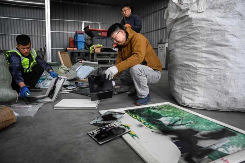 This photo taken on March 27, 2024 shows Liu Wei (right) and workers spraying paint on clients’ unwanted wedding photos at a warehouse in Langfang, in northern China’s Hebei province. — eNM pic