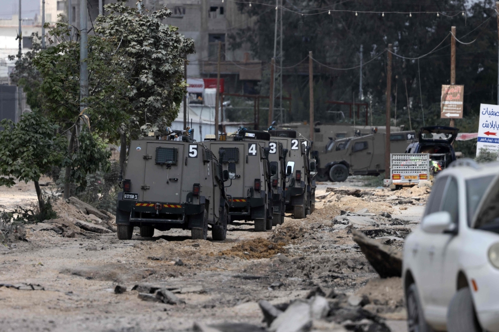 Israeli military vehicles drive along a devastated street in the Nur Shams refugee camp in the occupied West Bank, during a raid on April 19, 2024. — eNM pic