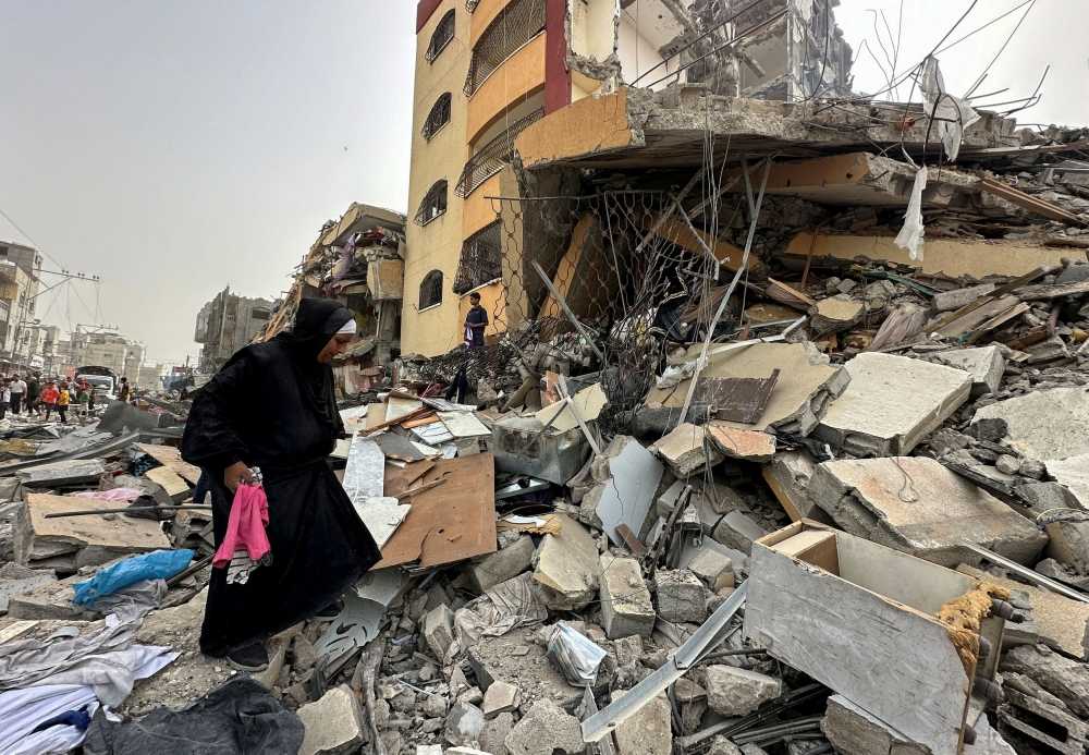 File photo of a Palestinian woman searching for her belongings after her apartment was destroyed in an Israeli raid, amid the ongoing conflict between Israel and the Palestinian Islamist group Hamas, in Nuseirat, in the central Gaza Strip, April 18, 2024. ― eNM pic