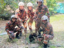 Bomba personnel with the captured sun bear cub. — The eNM pic