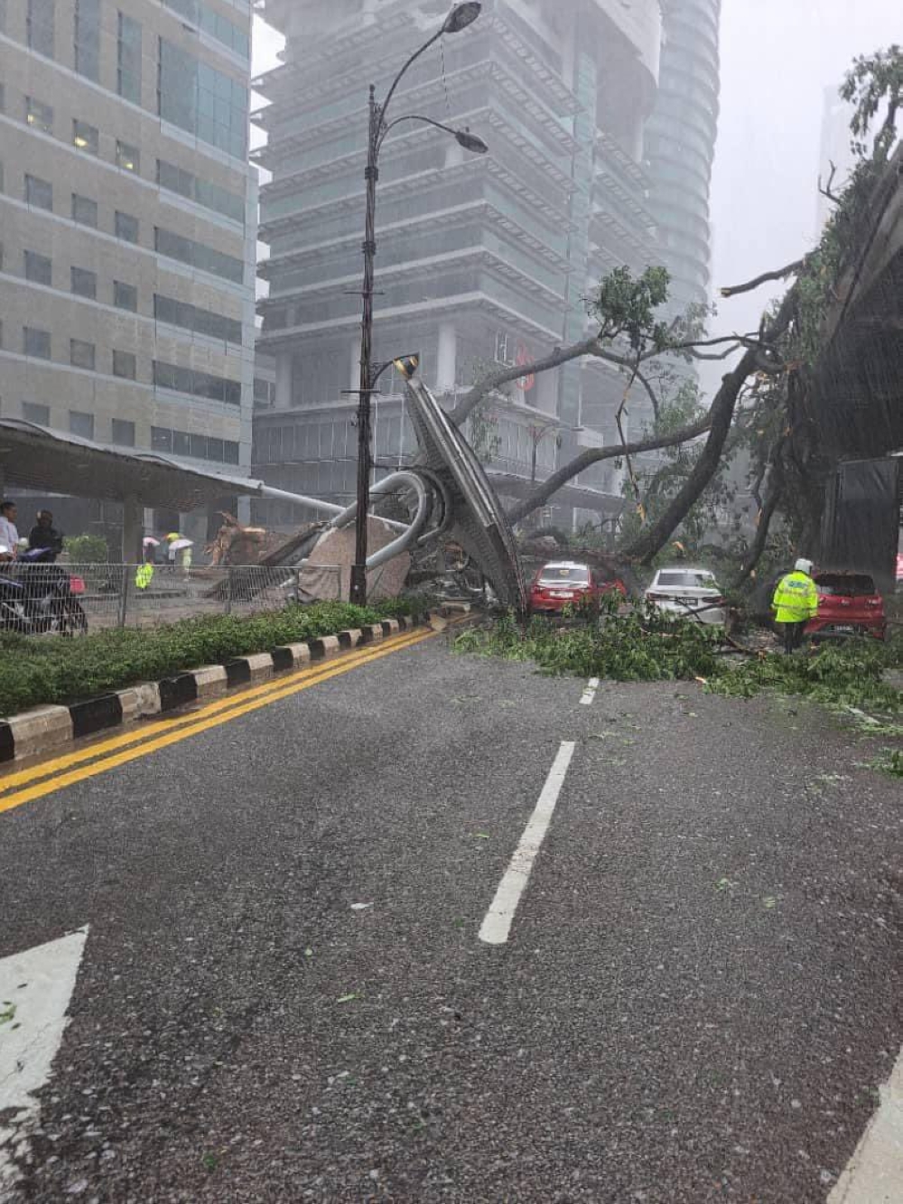Based on photos shared by users on social media site X, the fallen tree also tipped over a bus stop or taxi stand under it, trapping several vehicles that were passing by at that time. ― Picture via X