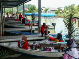Traders sell various types of food on boats at Pulau Suri Floating Market May 16, 2024. — eNM pic