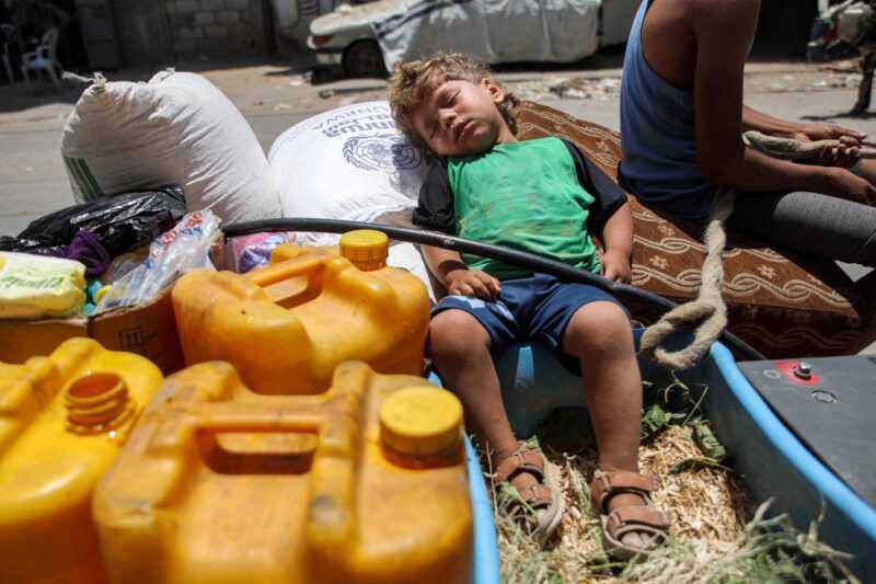 A boy sleeps on a sack of flour next to jerrycans in the back of an animal-drawn cart while evacuating from the Tuffah neighbourhood in the east of Gaza City heading towards areas in the west June 24, 2024 amid the ongoing conflict in the Palestinian territory between Israel and Hamas. — eNM pic